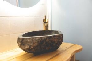 a bathroom with a large rock sink on a wooden table at La casa sul Monviso in Montoso