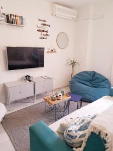 ein Wohnzimmer mit einem TV, einem Sofa und einem Tisch in der Unterkunft Apartamento "La Viña" in Málaga