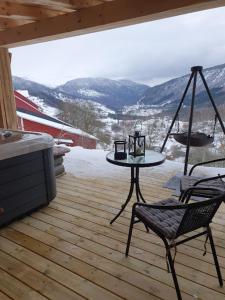 a patio with a table and a chair on a deck at Molden 1 - med Jacuzzi! in Luster