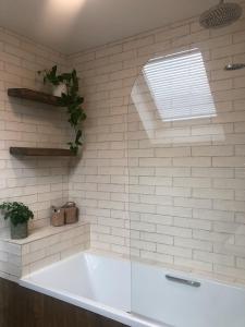 a white bath tub in a bathroom with a window at Sandyhill Guest House - Westport in Westport