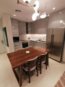 a kitchen with a wooden table and a refrigerator at Two Bedrooms Apartment at Address Residence Fujairah in Sharm