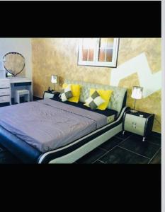 een slaapkamer met een groot bed met gele kussens bij Villa Caraibes in Petit-Canal