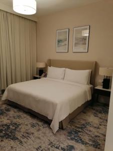 a bedroom with a large white bed and two lamps at Two Bedrooms Apartment at Address Residence Fujairah in Sharm