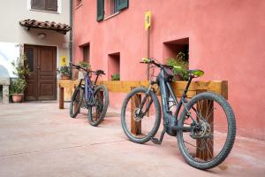 two bikes parked in front of a red building at B&B La Ceramica Moline in Vicoforte