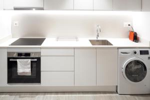 a white kitchen with a sink and a dishwasher at Mimi's Apartment in En Corts in Valencia