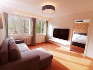 a living room with a couch and a flat screen tv at Center, Sauna - Haus LINARIA in Leukerbad