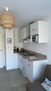 a kitchen with white cabinets and a counter top at Résidence l’Esprit de la mer in Combrit