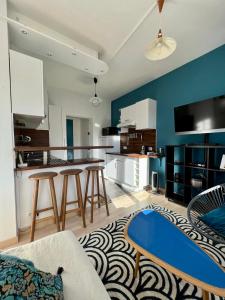 un soggiorno con cucina e pareti blu di Résidence Pleine mer a Saint-Pierre-en-Port