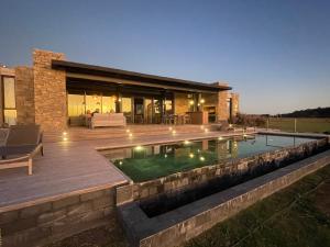 un patio trasero con piscina y una casa en La MaSia en Balneario Buenos Aires