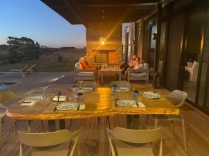 uma sala de jantar com uma mesa e cadeiras num deque em La MaSia em Balneario Buenos Aires