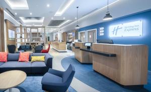 een kantoorlobby met een receptie en stoelen bij Holiday Inn Express - Fleet, an IHG Hotel in Fleet