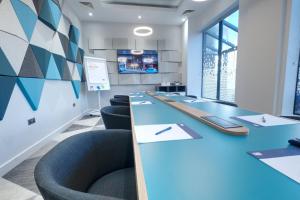 a conference room with blue tables and chairs at Holiday Inn Express - Fleet, an IHG Hotel in Fleet