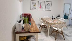 Apartamento "La Viña" في مالقة: مطبخ مع طاولة وكراسي وغرفة طعام
