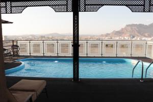 a swimming pool on the balcony of a building at Ewann Hotel Apartments in Nizwa