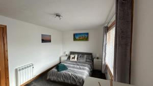 een slaapkamer met een bed en een raam bij 36 Westview Terrace in Stornoway