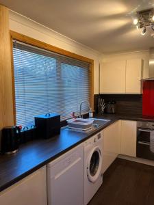 a kitchen with a washing machine on a counter at 36 Westview Terrace in Stornoway