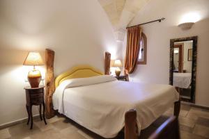 a bedroom with a large white bed and a mirror at Tenute Al Bano in Cellino San Marco