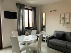 a living room with a table and chairs and a couch at Casa Patrito - appartamento Nebbiolo in Barolo