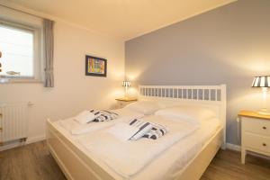 a bedroom with a large white bed with two pillows at Ferienwohnung Frahm in Hörnum