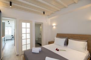 a bedroom with a large white bed with white pillows at The Mykonos Bougainvillea Townhouse in Mýkonos City