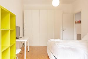 - une chambre avec un lit, un bureau et une télévision dans l'établissement BnButler - Casa Lario - Isola District, à Milan