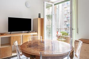 une salle à manger avec une table et une télévision dans l'établissement BnButler - Casa Lario - Isola District, à Milan