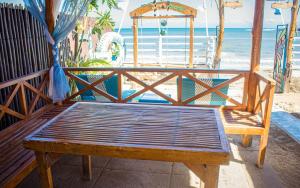 a wooden bench sitting on the beach near the ocean at HAVEN BREEZE RESORT - A home of Hundred Islands in Alaminos
