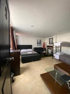een woonkamer met 2 bedden en een bank bij Destino Nómada Calle 11 n 1-38 in Bogota
