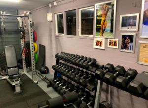 een fitnessruimte met rijen halters aan de muur bij Oakland in Kettering