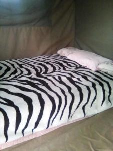 a black and white bed with a pillow on it at Nahubwe Safari Lodge in Ngoma