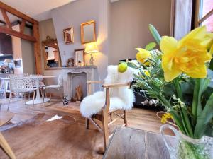 una silla blanca en una sala de estar con flores en LE VALENTIN - Parking privé offert - Coeur Historique -La Clef de Honfleur, en Honfleur