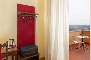 a room with a curtain and a table and a window at Hotel Sacro Cuore in Perugia