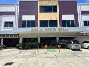 a large building with cars parked in a parking lot at Ayla City Hotel in Sorong