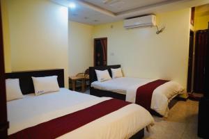 um quarto de hotel com duas camas num quarto em Elite Cox's Resort em Cox's Bazar