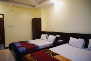 um quarto de hotel com duas camas num quarto em Elite Cox's Resort em Cox's Bazar