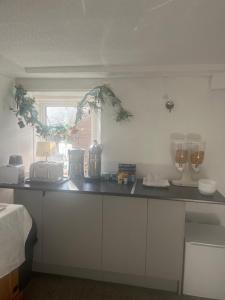 una cucina con armadi bianchi e piano di lavoro di DunMoore Guesthouse a Oban