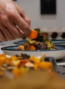 a person holding a carrot on a plate of food at Chalet Ski Académie - Serre Chevalier in Saint-Chaffrey +28 photos