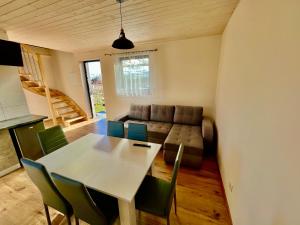 a living room with a table and a couch at Apartament na Ogrodowej - 2 sypialnie, ogród, taras, parking in Trzęsacz