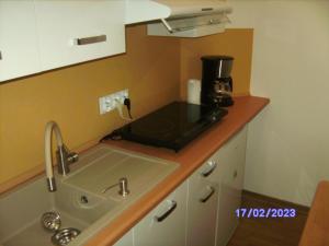 eine Küche mit einer Spüle und einer Kaffeemaschine auf der Theke in der Unterkunft Appartment Bawaria in Cieszyn