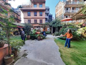 a little girl playing with a hose in a yard at Pradhan House - Home Stay with Garden in Bhaktapur