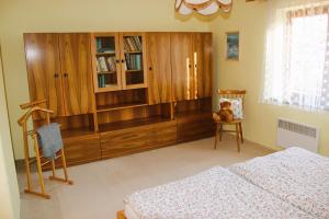 1 dormitorio con armarios de madera y un osito de peluche sentado en una silla en Chalupa u Procházků en Meziměstí