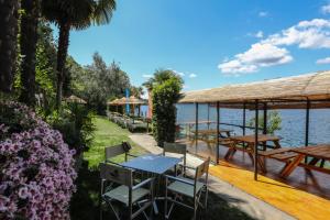a table and chairs on a deck next to the water at Residence Casa Coppa Appartamento Flox in Omegna