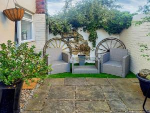 a group of chairs sitting in the back of a house at The Saddlers Cottage in East Boldon