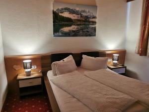 a bedroom with a bed and two night stands with lamps at Haus Martha in Kaunertal