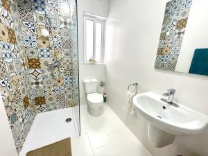 een badkamer met een toilet, een wastafel en een douche bij Ta Phyllis - Apartments & Villas with Sunset & Sea Views in Għajnsielem