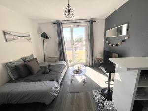 a living room with a couch and a table at Charmant Studio in Talence