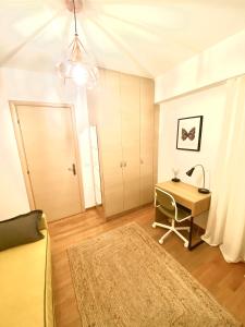 a room with a desk and a table with a lamp at Little John Luxury Apartment in Piraeus