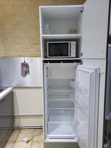 una nevera vacía con microondas en la cocina en STUDIO DONDAINES en Lille
