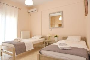 2 camas sentadas en una habitación con espejo en Lila's Villa en Nerotriviá