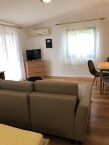 ein Wohnzimmer mit einer Couch und einem Tisch in der Unterkunft DD apartmani in Krk